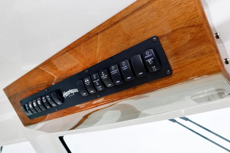 Slide: The Image of Control panel of 2023 Henriques 42 Express Hardtop with wooden finish and labeled switches. - 36