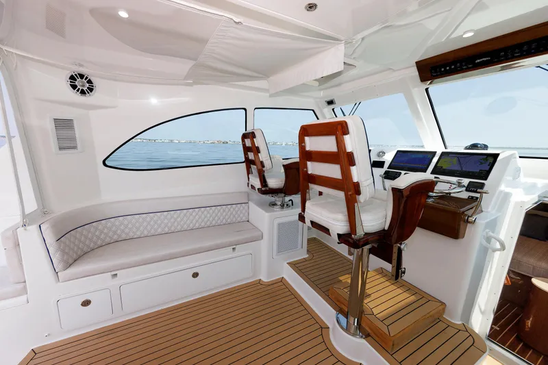 Slide: The Image of 2023 Henriques 42 Express Hardtop interior with helm, seating, and navigation displays. - 37