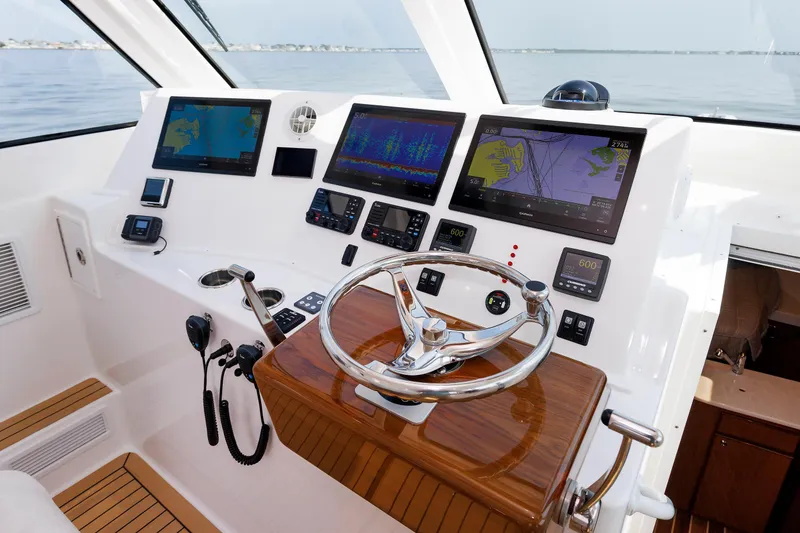 Slide: The Image of 2023 Henriques 42 Express Hardtop helm with advanced navigation displays and controls. - 44