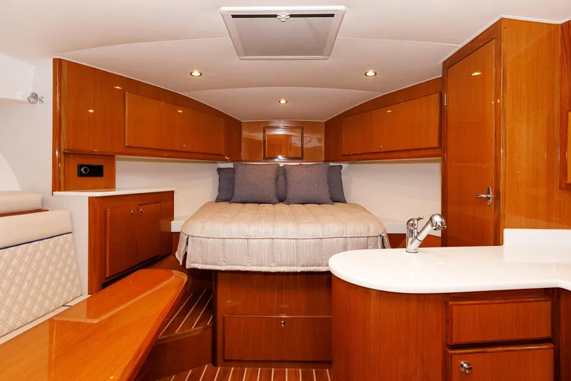 Slide: The Image of 2023 Henriques 42 Express Hardtop cabin interior with wood finish and cozy bed. - 52