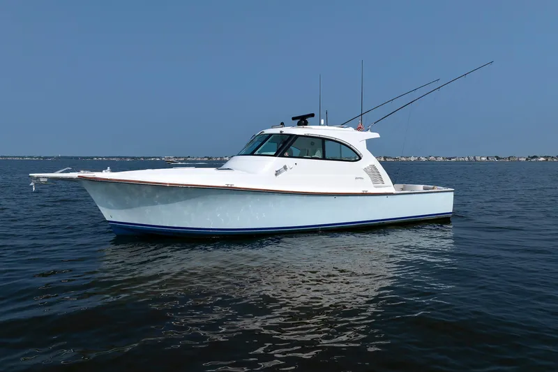 Slide: The Image of 2023 Henriques 42 Express Hardtop boat on calm water, clear sky background. - 7