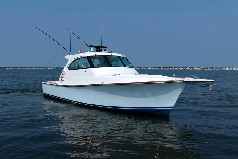 Slide: The Image of 2023 Henriques 42 Express Hardtop boat on calm water, clear sky background. - 9