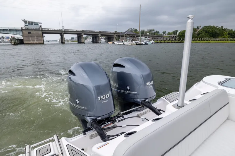 Slide: The Image of 2023 Sea Fox 268 Commander with twin Yamaha 150 engines on a river near a bridge. - 24