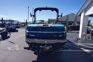 Slide: The Image of 2025 MasterCraft NXT23 boat in a parking lot, rear view, sunny day. - 3