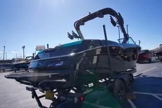 Slide: The Image of 2025 MasterCraft NXT23 boat on trailer under clear blue sky. - 4