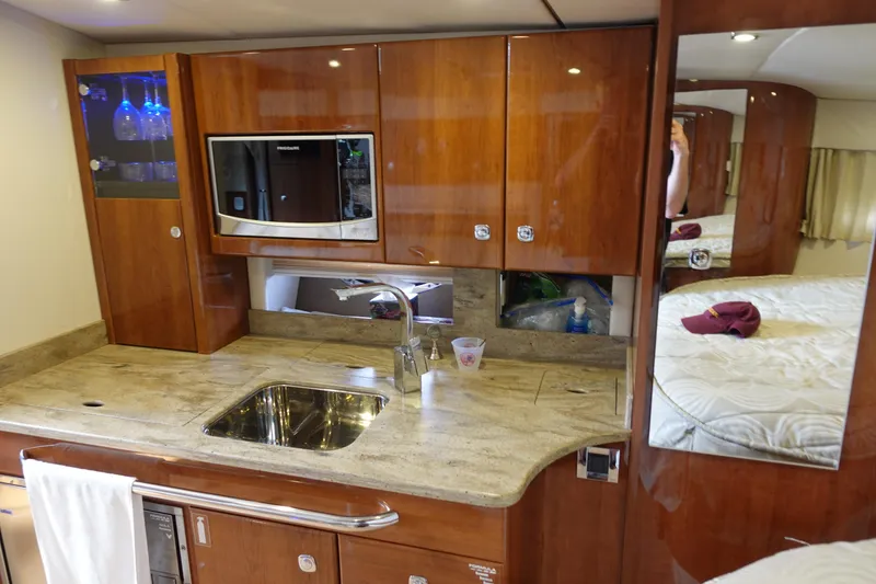 Slide: The Image of Luxurious kitchen area in a 2016 Formula 34 Cruiser yacht with wood cabinetry and modern appliances. - 16