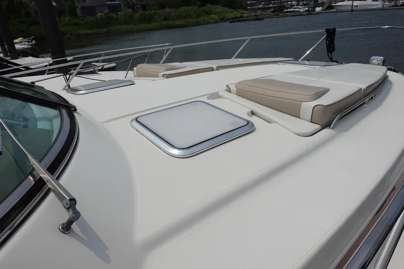 Slide: The Image of 2016 Formula 34 Cruiser yacht deck with sun pads and hatch, docked by the water. - 5