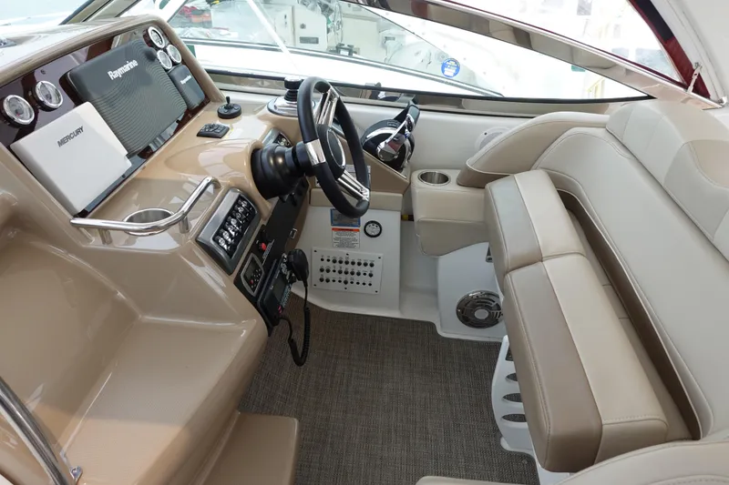 Slide: The Image of 2016 Formula 34 Cruiser helm with beige seating, steering wheel, and navigation equipment. - 7