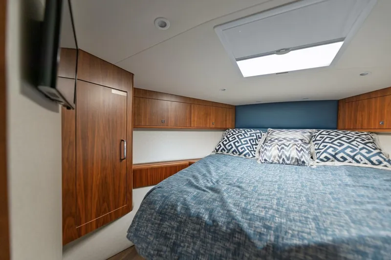 Slide: The Image of Luxurious cabin interior of 2018 Hatteras GT45X Flybridge with wood cabinetry and patterned bedding. - 15