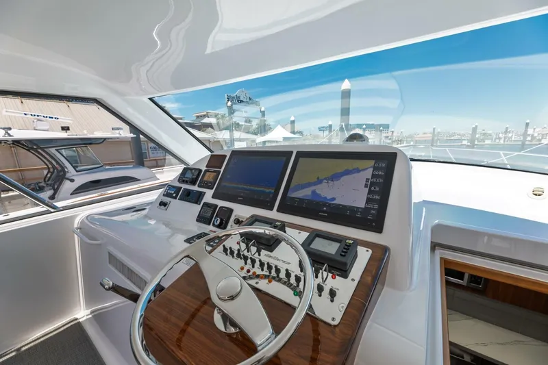 Slide: The Image of 2018 Hatteras GT45X Flybridge helm with navigation screens and controls. - 21
