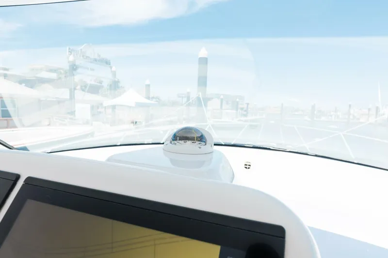 Slide: The Image of 2018 Hatteras GT45X Flybridge helm with navigation equipment and marina view. - 23