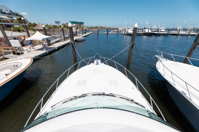 Slide: The Image of 2018 Hatteras GT45X Flybridge yacht docked at a marina under clear blue skies. - 25
