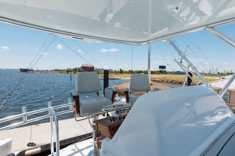Slide: The Image of 2018 Hatteras GT45X Flybridge with helm chairs overlooking marina and waterway. - 26