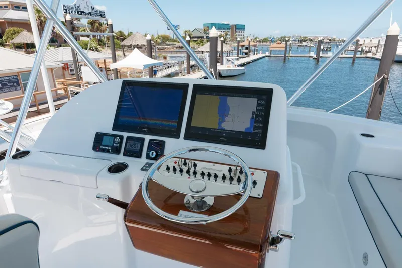 Slide: The Image of 2018 Hatteras GT45X Flybridge helm with navigation screens at marina. - 28