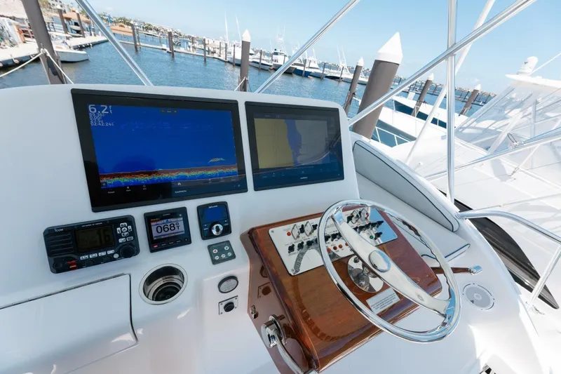 Slide: The Image of Flybridge helm of 2018 Hatteras GT45X with navigation screens and controls, docked at marina. - 29