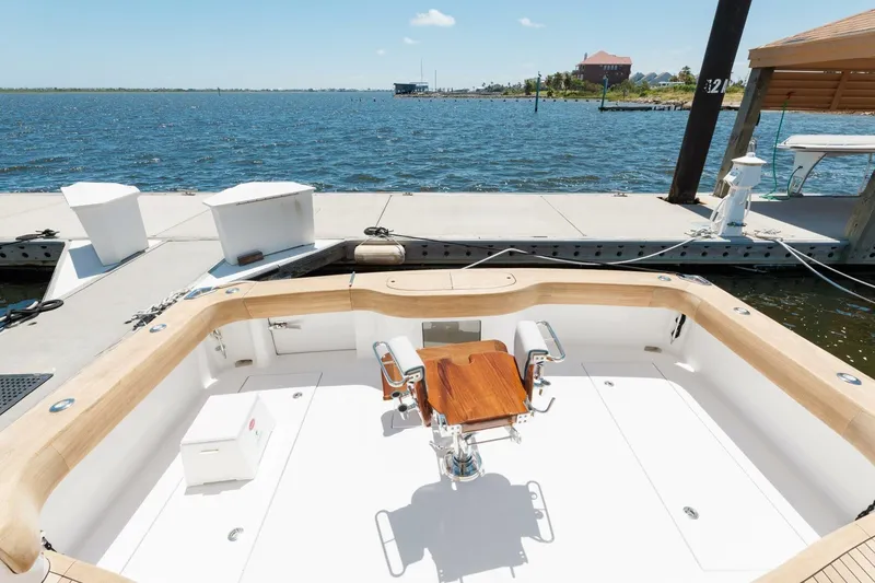 Slide: The Image of 2018 Hatteras GT45X Flybridge at dock, featuring spacious cockpit and scenic waterfront view. - 32