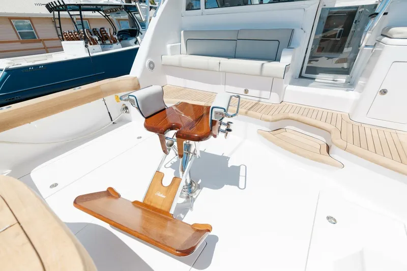 Slide: The Image of 2018 Hatteras GT45X Flybridge cockpit with wooden fighting chair and cushioned seating. - 37