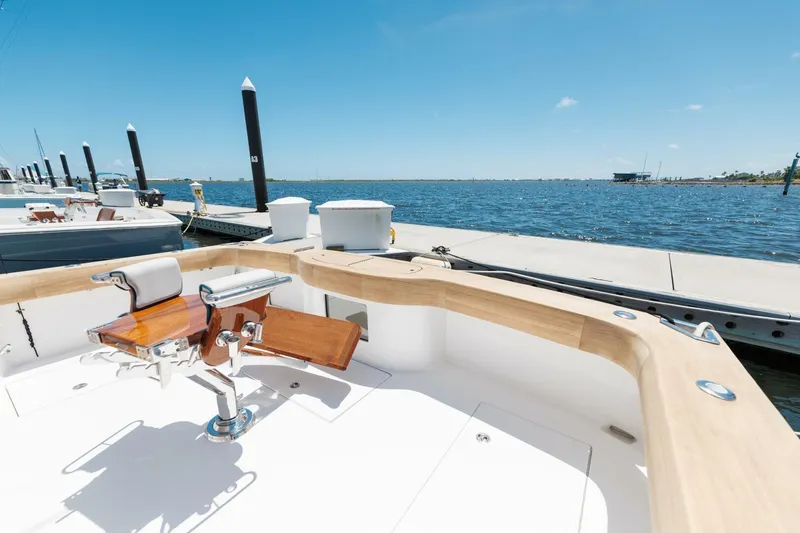 Slide: The Image of 2018 Hatteras GT45X Flybridge at dock, featuring a fishing chair and ocean view. - 39