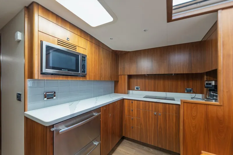 Slide: The Image of Luxurious 2018 Hatteras GT45X Flybridge yacht kitchen with wood cabinetry and modern appliances. - 4