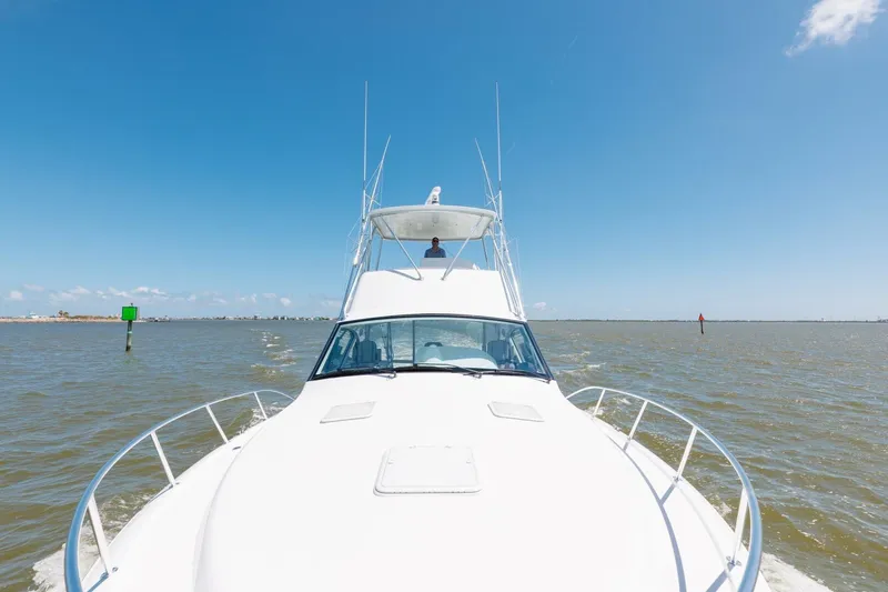 Slide: The Image of 2018 Hatteras GT45X Flybridge cruising on open water under clear blue sky. - 44