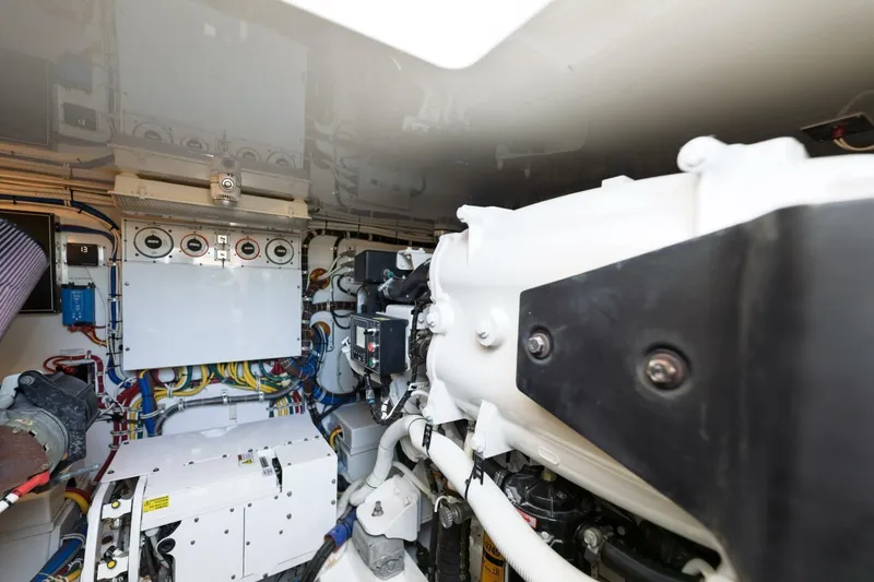 Slide: The Image of Engine room of 2018 Hatteras GT45X Flybridge, showcasing mechanical components and wiring. - 49