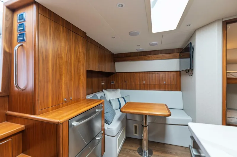 Slide: The Image of 2018 Hatteras GT45X Flybridge interior with wood cabinetry, dining area, and modern amenities. - 9