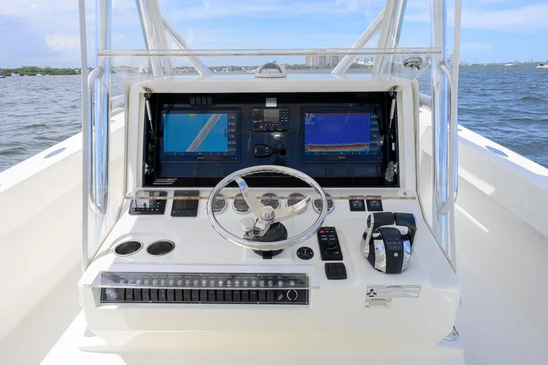 Slide: The Image of 2017 SeaVee 390 boat helm with dual screens and steering wheel on open water. - 10