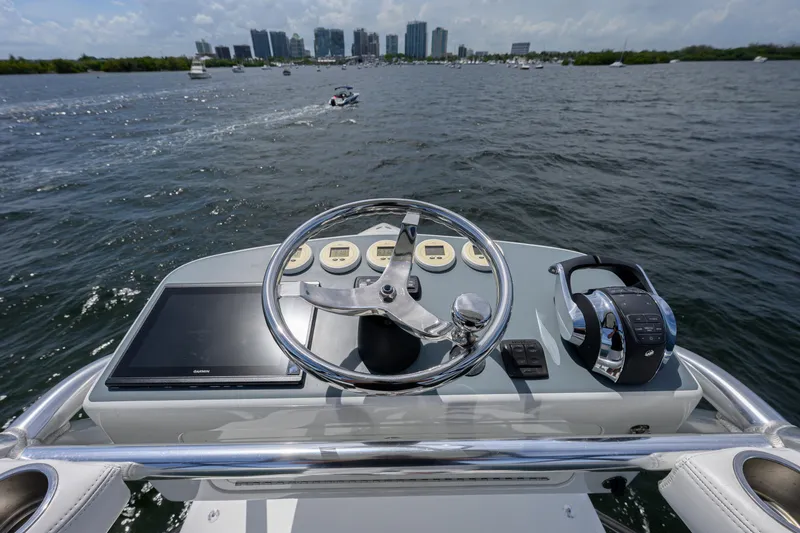 Slide: The Image of 2017 SeaVee 390 helm with steering wheel, controls, and city skyline in the background. - 11