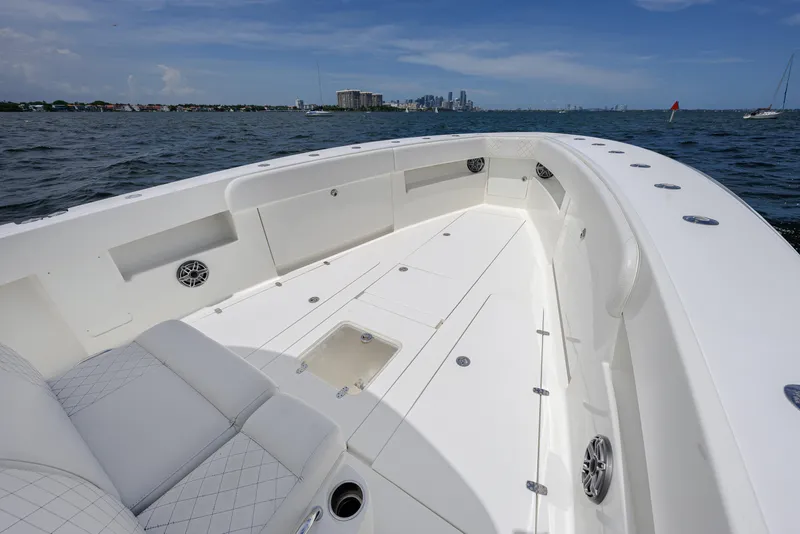 Slide: The Image of 2017 SeaVee 390 boat deck with spacious seating, ocean view, and city skyline in the background. - 8