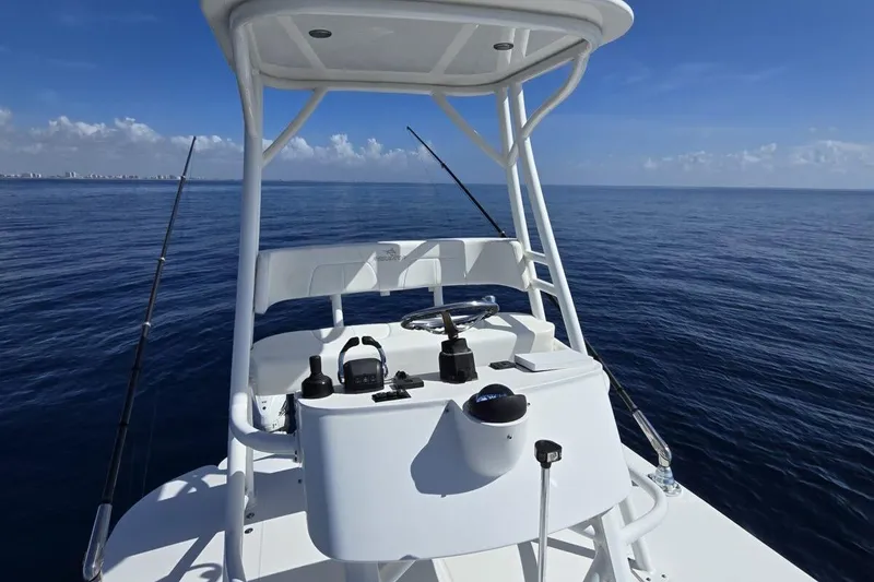 Slide: The Image of 2020 Regulator Motor Yacht helm with ocean view, clear skies, and fishing rods. - 6