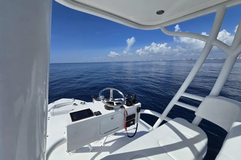 Slide: The Image of 2020 Regulator Motor Yacht helm with ocean view, clear skies, and distant coastline. - 7