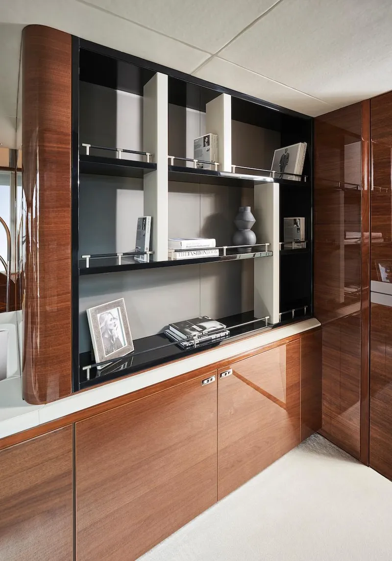 Slide: The Image of Luxurious interior of 2025 Princess X95 yacht with elegant wooden cabinetry and modern shelving. - 28