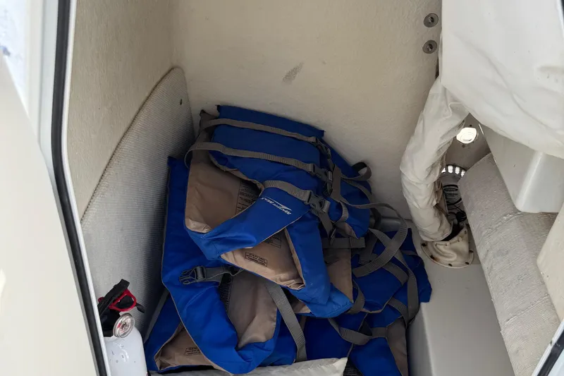 Slide: The Image of Blue life jackets stored in a 2008 Sea Hunt 220 Triton boat compartment. - 24
