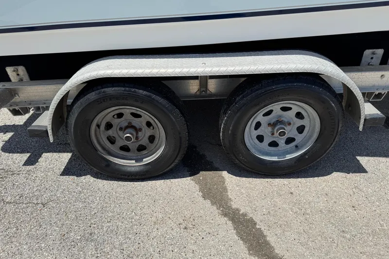 Slide: The Image of Trailer wheels of a 2008 Sea Hunt 220 Triton boat on asphalt. - 27