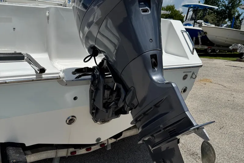 Slide: The Image of 2008 Sea Hunt 220 Triton boat with outboard motor, parked on a trailer. - 29