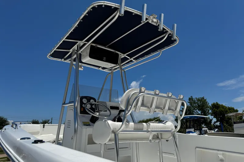 Slide: The Image of 2008 Sea Hunt 220 Triton boat with T-top and helm, under clear blue sky. - 30