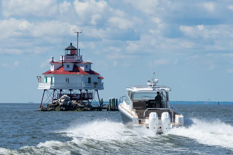 Slide: The Image of Nimbus W11 #46 boat near a historic lighthouse on a sunny day, 2025. - 1