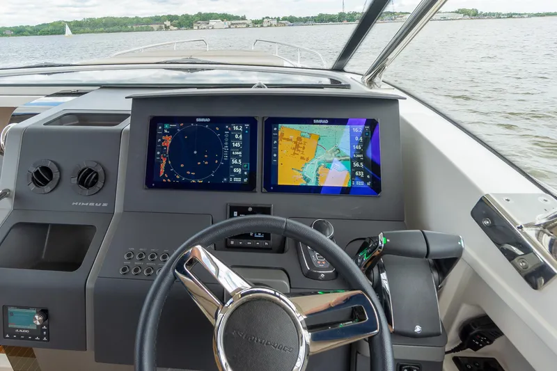 Slide: The Image of Steering wheel and navigation screens on Nimbus W11 #46 boat, 2025 model, on a lake. - 23