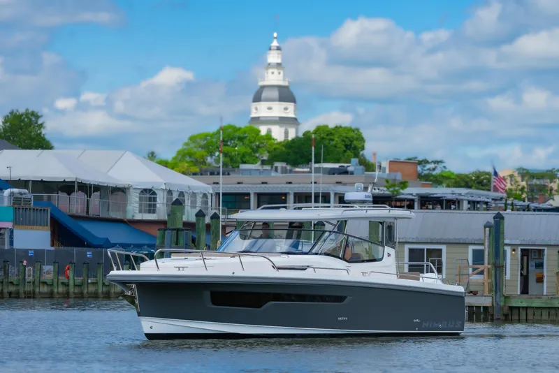Slide: The Image of Nimbus W11 #46 boat docked with a scenic cityscape and historic building in the background. - 63