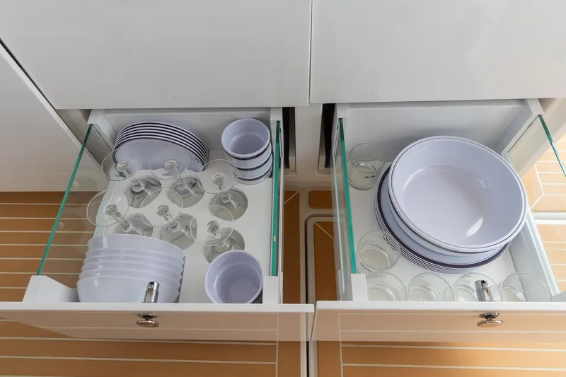 Slide: The Image of Modern kitchen drawers with neatly organized dishes and glassware in a Nimbus W11 #46, 2025 model. - 77