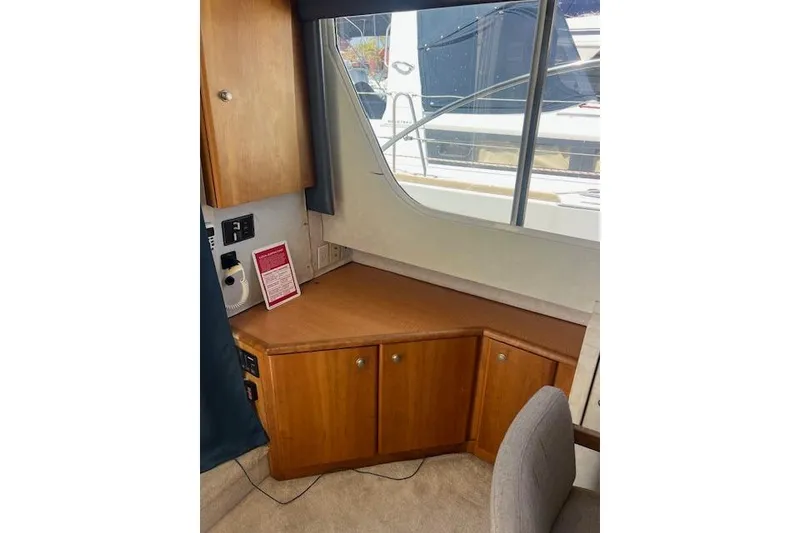 Slide: The Image of 1997 Silverton 351 Sedan interior with wooden cabinets and window view. - 15