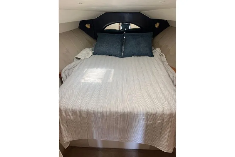 Slide: The Image of 1997 Silverton 351 Sedan cabin with cozy bed and blue pillows. - 18