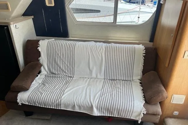 Slide: The Image of 1997 Silverton 351 Sedan interior with striped sofa cover and window view. - 16