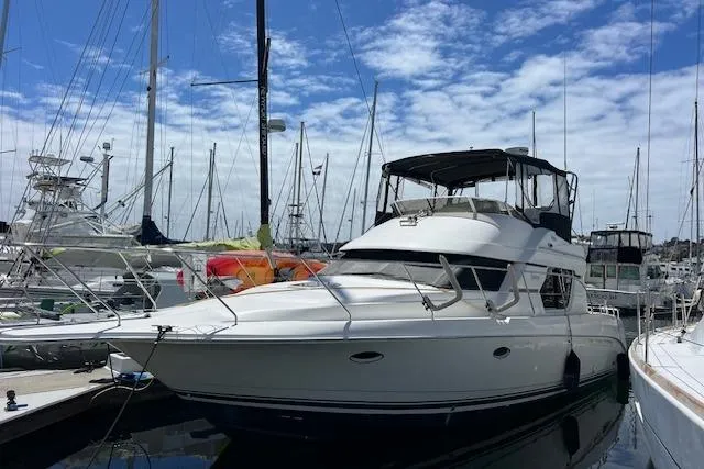 Slide: The Image of 1997 Silverton 351 Sedan Cruiser docked at marina under blue sky. - 4