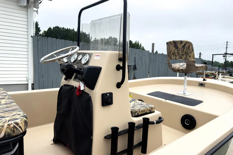 Slide: The Image of 2026 Carolina Skiff E18 JVX CC Sportsman boat interior with steering console and camo seating. - 30