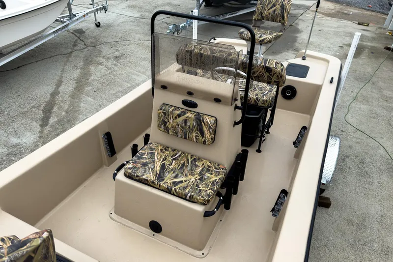Slide: The Image of 2026 Carolina Skiff E18 JVX CC Sportsman boat with camo seats, parked on a trailer. - 36