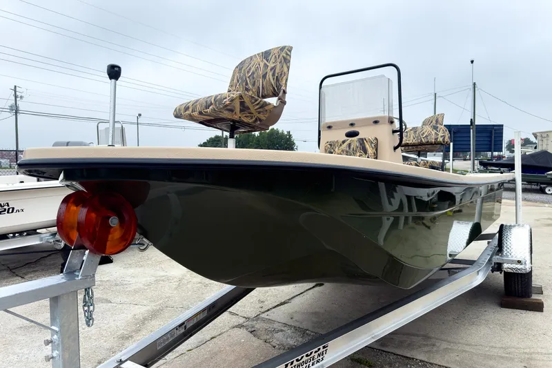 Slide: The Image of 2026 Carolina Skiff E18 JVX CC Sportsman boat on trailer, featuring camo seats. - 37