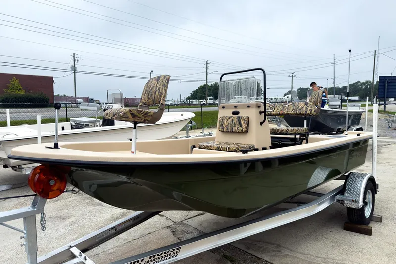 Slide: The Image of 2026 Carolina Skiff E18 JVX CC Sportsman boat on trailer, camo seats, outdoor setting. - 38