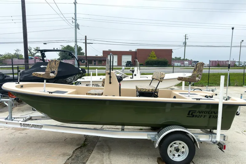 Slide: The Image of 2026 Carolina Skiff E18 JVX CC Sportsman boat on trailer, parked outdoors. - 4