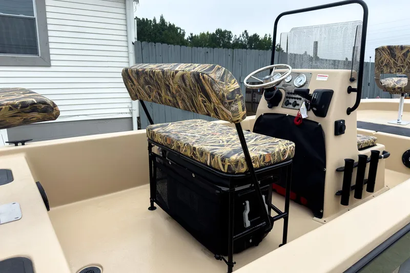 Slide: The Image of 2026 Carolina Skiff E18 JVX CC Sportsman boat interior with camo seats and steering console. - 8